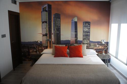 a bedroom with a large bed with a mural of skyscrapers at Arizonica Suites in Madrid