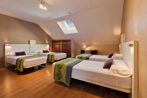 Habitación de hotel con 3 camas y tragaluz en Hotel Fuente El Cura, en Sax