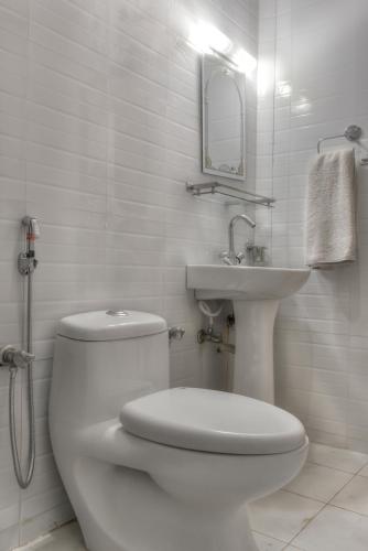 Un baño blanco con inodoro y lavabo. en Hotel Kamal, en Katmandú