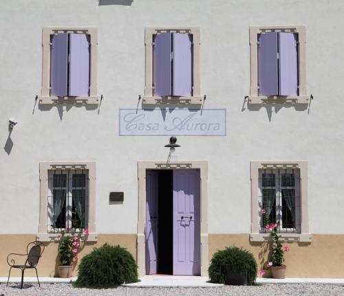 a building with a purple door and windows at Agriturismo Casa Aurora in Bussolengo