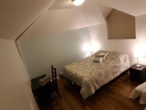 a bedroom with a bed and two lights on at Emperial Suites in North Vancouver