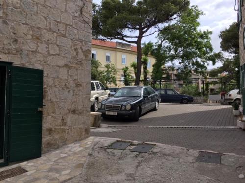 a car parked in a parking lot next to a building at room Ami in Kaštela