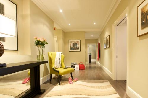 a hallway with a yellow chair and a desk at Taj 51 Buckingham Gate Suites and Residences in London