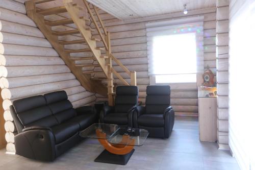 a living room with two chairs and a staircase at Sosnowe Domki in Rewal