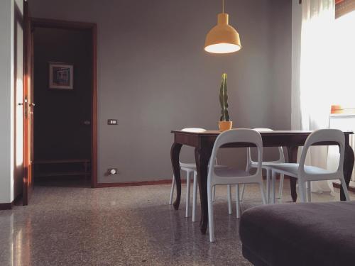 a dining room with a table and white chairs at Sunny family apartment in villa - HUMANITAS FORUM IEO in Pieve Emanuele