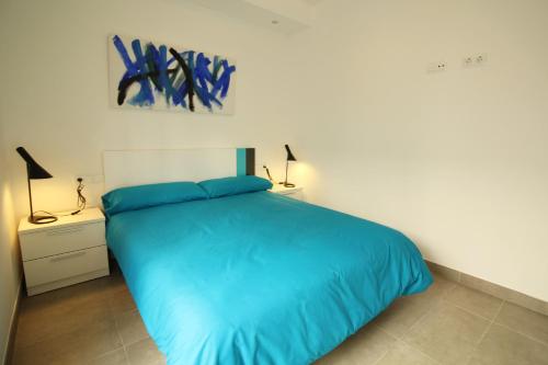 サン・ペドロ・デル・ピナタルにあるVilla Alegreのベッドルーム1室(青い掛け布団付きのベッド1台付)