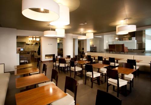 comedor con mesas y sillas de madera en Porto Antas Hotel en Oporto