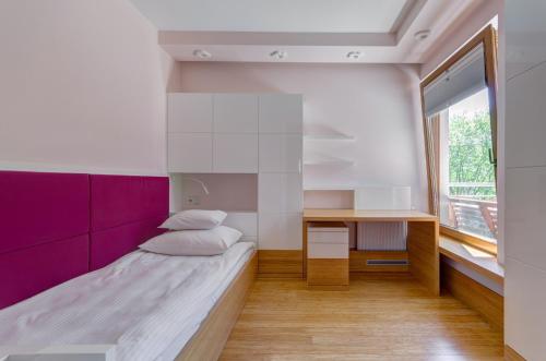 um pequeno quarto com uma cama e uma secretária em Orlowska43 em Gdynia