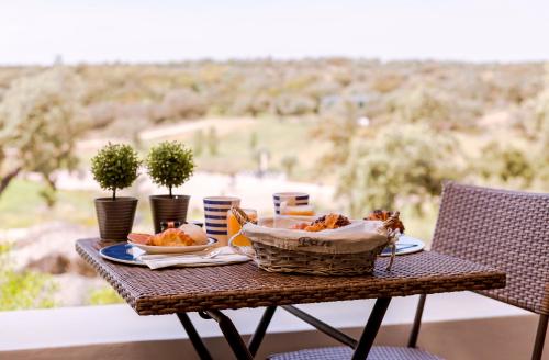 a table with a basket of food on a balcony at Monte Velho Equo-Resort in Arraiolos
