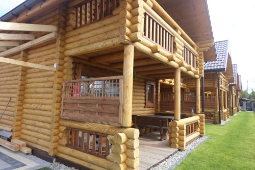 a log cabin with a table in front of it at Sosnowe Domki in Rewal