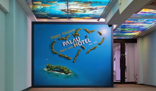 a wall in a hallway with a painting of a world on it at Palau Hotel in Koror