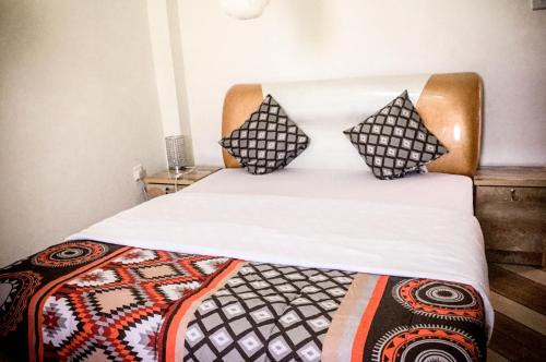 MbaleにあるMbale Travellers Innの枕が2つ置かれたベッド