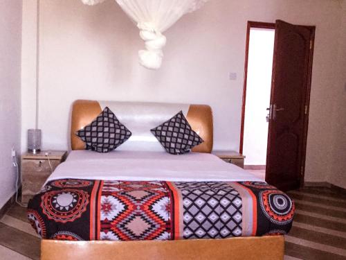 a bed with pillows on it in a bedroom at Mbale Travellers Inn in Mbale