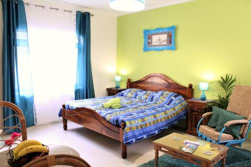 a bedroom with a bed and a chair at Avalon seaside studios - Gozo Bellevue Homes in Xlendi