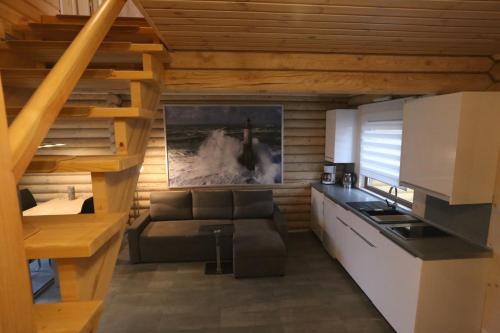 a living room with a couch and a kitchen at Sosnowe Domki in Rewal