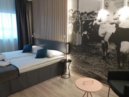 a hotel room with a bed and a picture of a player at Kalev Spa Hotel & Waterpark in Tallinn
