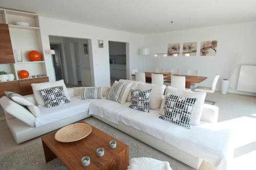 a living room with a white couch and a table at De Haan - Apartment Silverbeach in De Haan