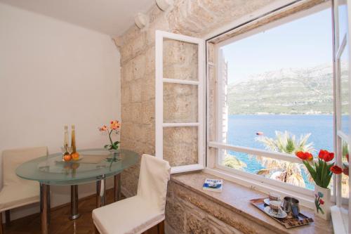 a room with a table and a large window at Guest House Holiday in Korčula