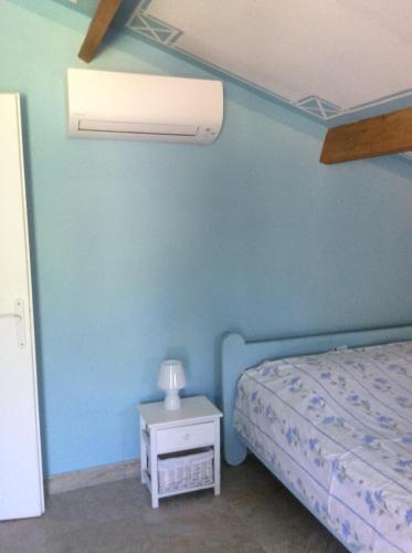 sypialnia z niebieską ścianą z łóżkiem i stołem w obiekcie Appartement les Ecureuils w mieście La Roque-dʼAnthéron