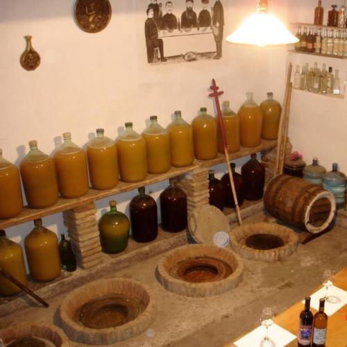 a group of yellow vases on shelves in a room at Gogi Dvalishvili Wine Cellar in Gori
