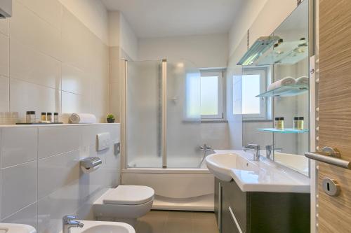 a bathroom with a toilet and a sink and a shower at Adriatic Apartments Fažana in Fažana