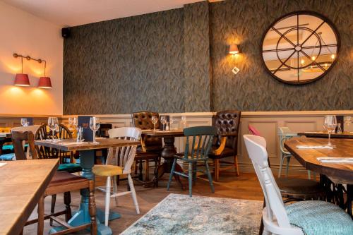 a restaurant with tables and chairs and a clock on the wall at City Gate in Exeter