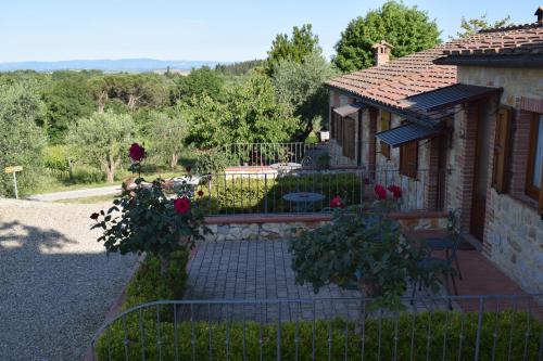 a house with a fence and a garden with roses at Agriturismo Amina, Winery & Hiking in Vagliagli
