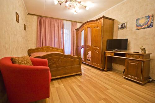 モスクワにあるLakshmi Great Apartment VDNHのリビングルーム(ベッド1台、テレビ、椅子付)