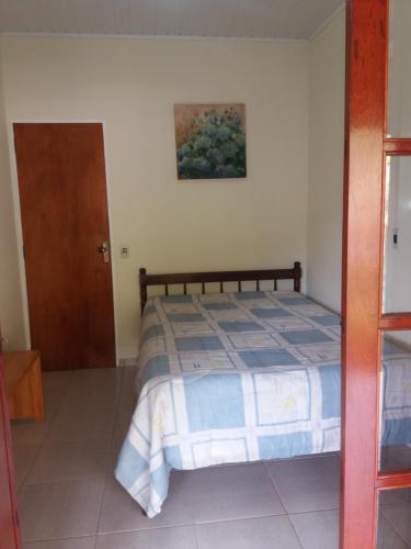 una camera da letto con un letto e un quadro sul muro di Sítio da Dinda - Campos do Jordão a Rosas