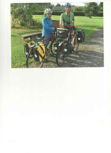 a man and a woman standing next to their bikes at Villa River Rose in Jõesuu