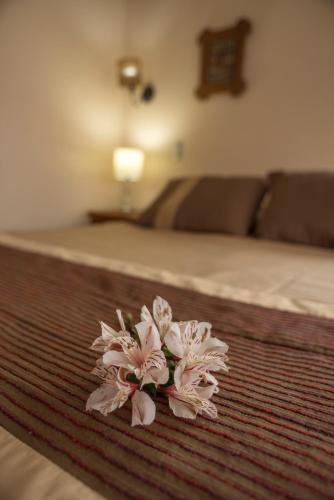 a pile of pink flowers on a bed at Weisserhaus in Puerto Varas