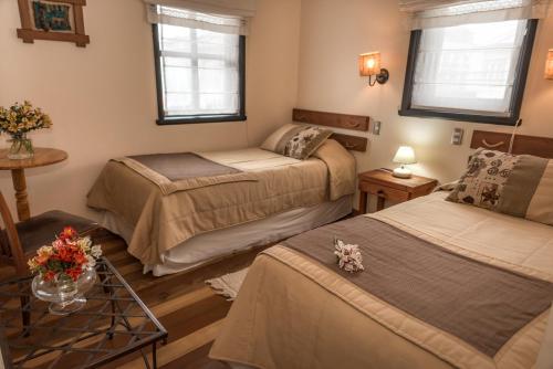 um quarto com duas camas e uma mesa com flores em Weisserhaus em Puerto Varas