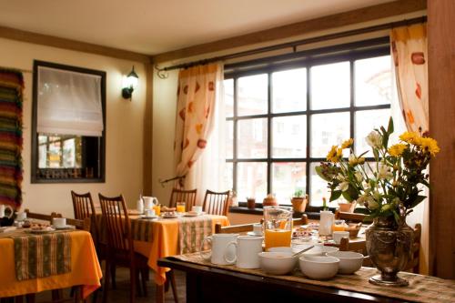 uma sala de jantar com mesas e cadeiras e uma grande janela em Weisserhaus em Puerto Varas