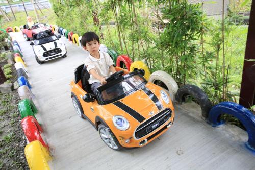 a young boy riding in an orange toy car at Sweetheart Homestay in Luodong