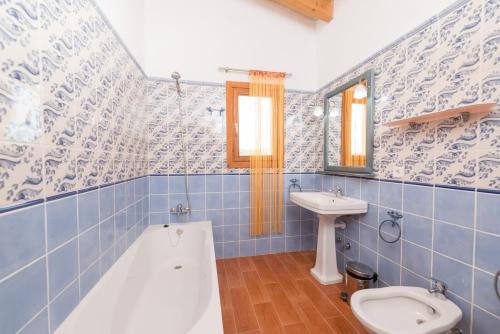 a bathroom with a tub and a toilet and a sink at Can Canals in Artá