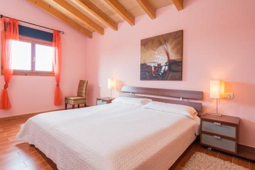a bedroom with a large white bed and a window at Can Canals in Artá