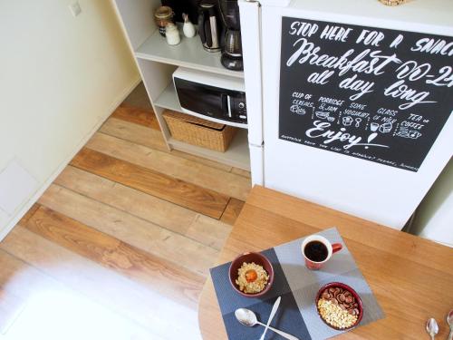 a table with bowls of food and a sign on a refrigerator at Amber Private Rooms in Rīga