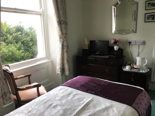a bedroom with a bed and a window at Bron Orme Private Hotel in Llandudno