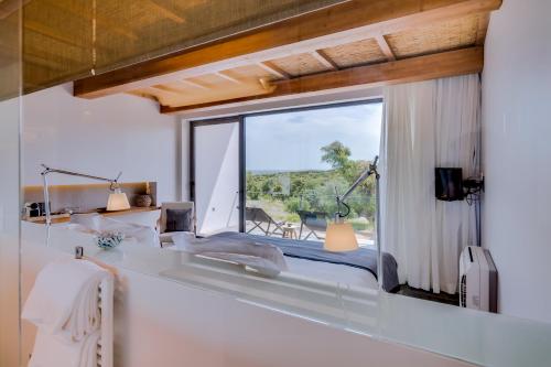 a bedroom with a large window with a view at Monte Velho Equo-Resort in Arraiolos