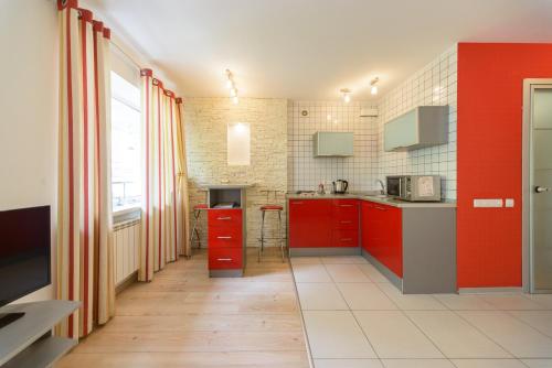 a kitchen with red cabinets and a red wall at Partner Guest House in Kyiv