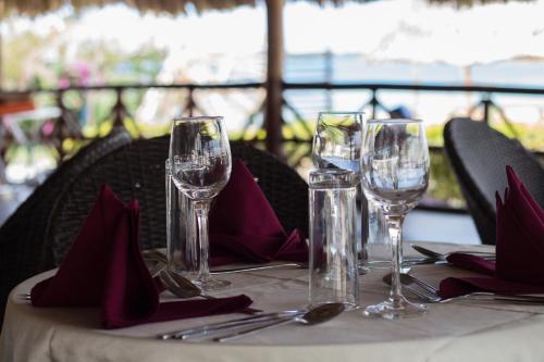 una mesa con copas de vino y servilletas. en Landmark Mbezi Beach Resort, en Dar es Salaam