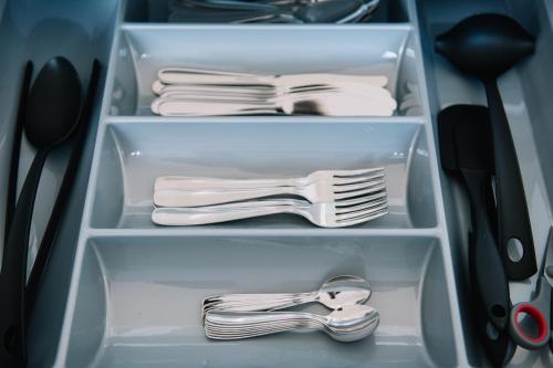 a drawer with plates and utensils in a refrigerator at Hestia Apartments Seaport in Tallinn