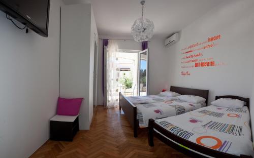 a room with two beds and a chair in it at Villa Marijeta Hvar in Hvar