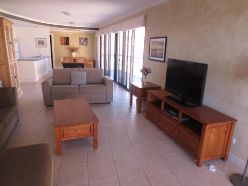 a living room with a television and a couch at Lights Landing Apartments in Adelaide