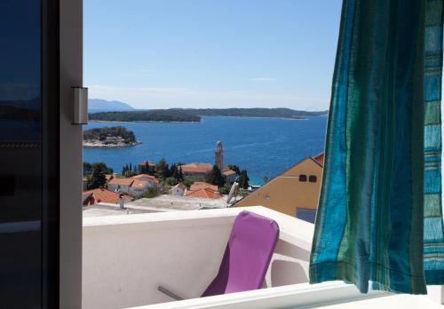 a purple chair sitting on a balcony with a view of the water at Villa Marijeta Hvar in Hvar