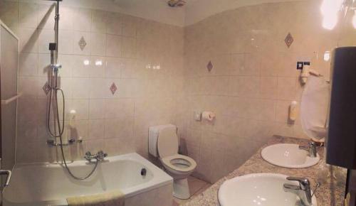 La salle de bains est pourvue d'une baignoire, de toilettes et d'un lavabo. dans l'établissement Hotel La Crémaillère, à Jalhay