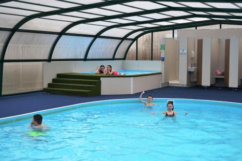 a swimming pool with three people in it at Campsie Glen Holiday Park in Fintry
