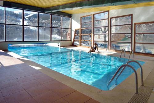 a swimming pool with a tub and a chair in it at Evenia Monte Alba in Cerler