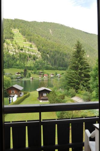 a view from a window of a lake and a mountain at Pension Seeheim in Weissensee