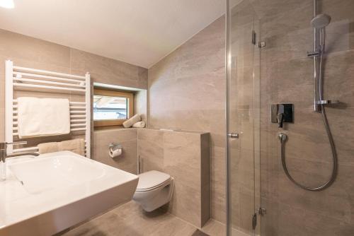 a bathroom with a shower and a toilet and a sink at Apartments Foidl in Kitzbühel